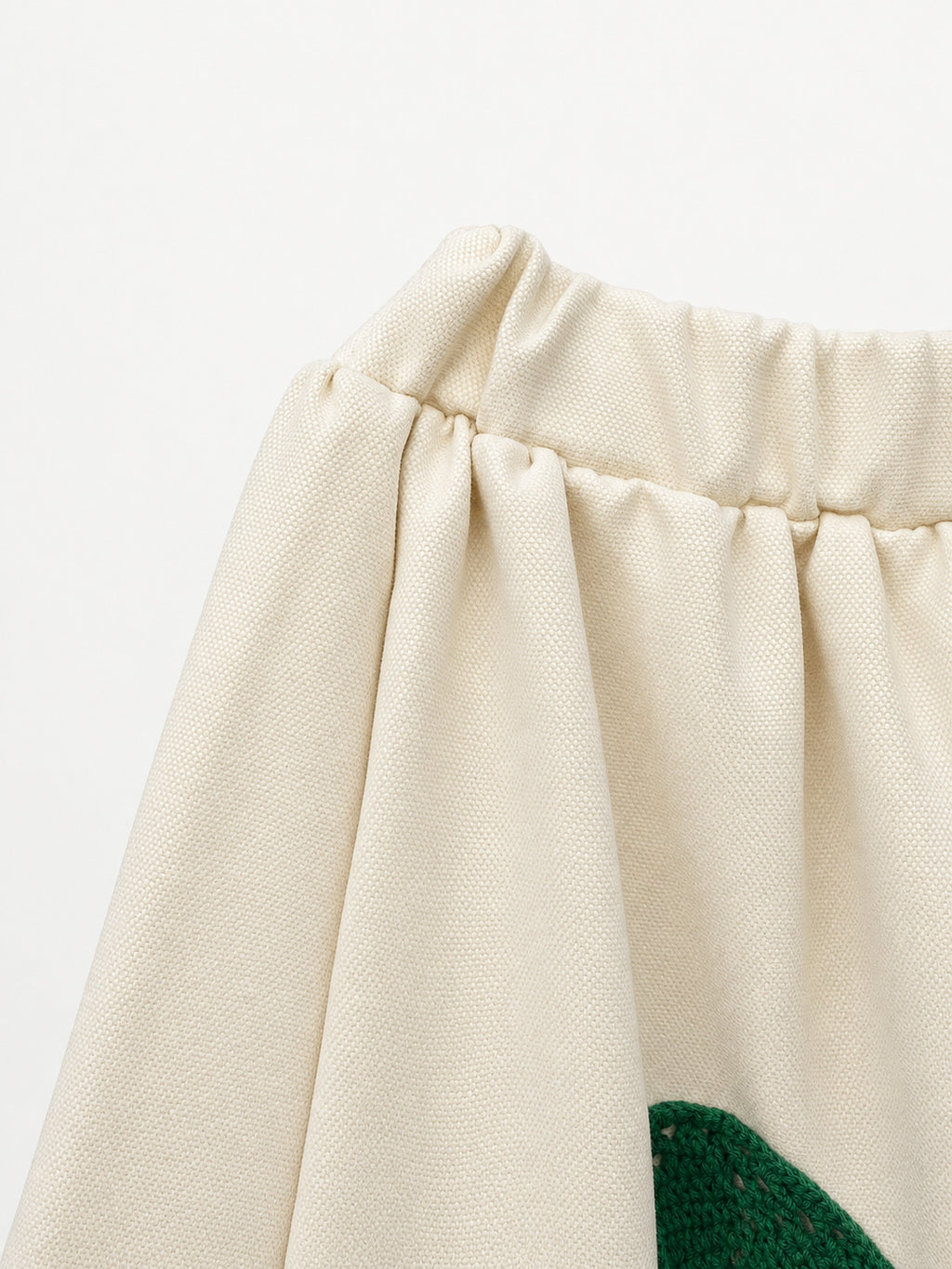 Cream skirt with green crocheted motifs and a delicate lace-trimmed hem