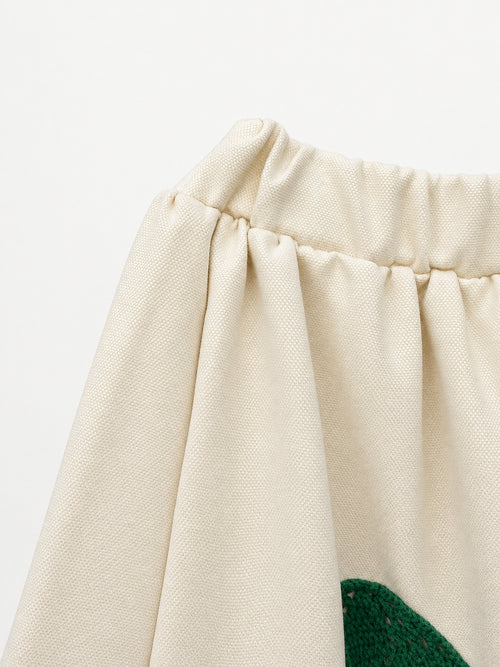 Cream skirt with green crocheted motifs and a delicate lace-trimmed hem