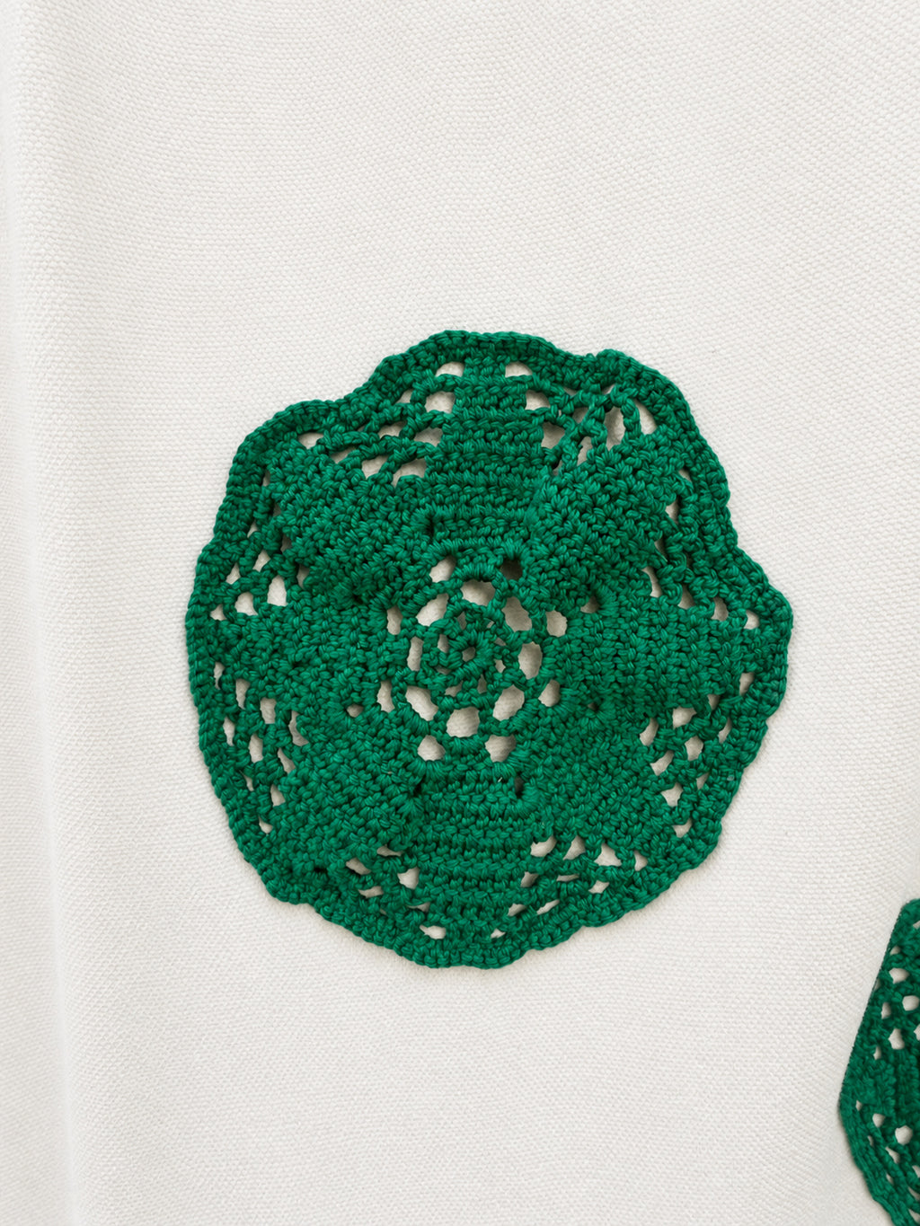 Cream skirt with green crocheted motifs and a delicate lace-trimmed hem