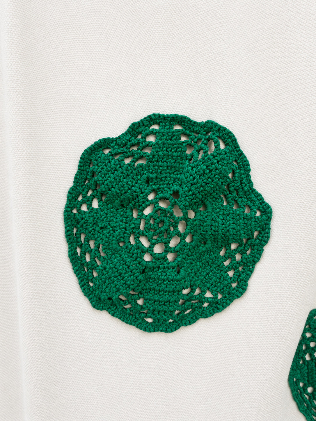 Cream skirt with green crocheted motifs and a delicate lace-trimmed hem