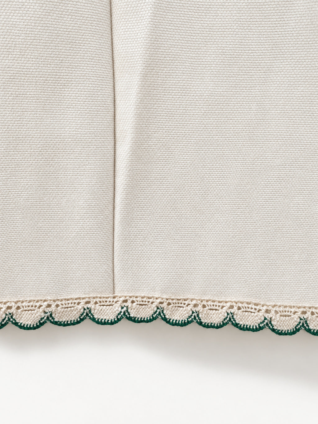 Cream skirt with green crocheted motifs and a delicate lace-trimmed hem