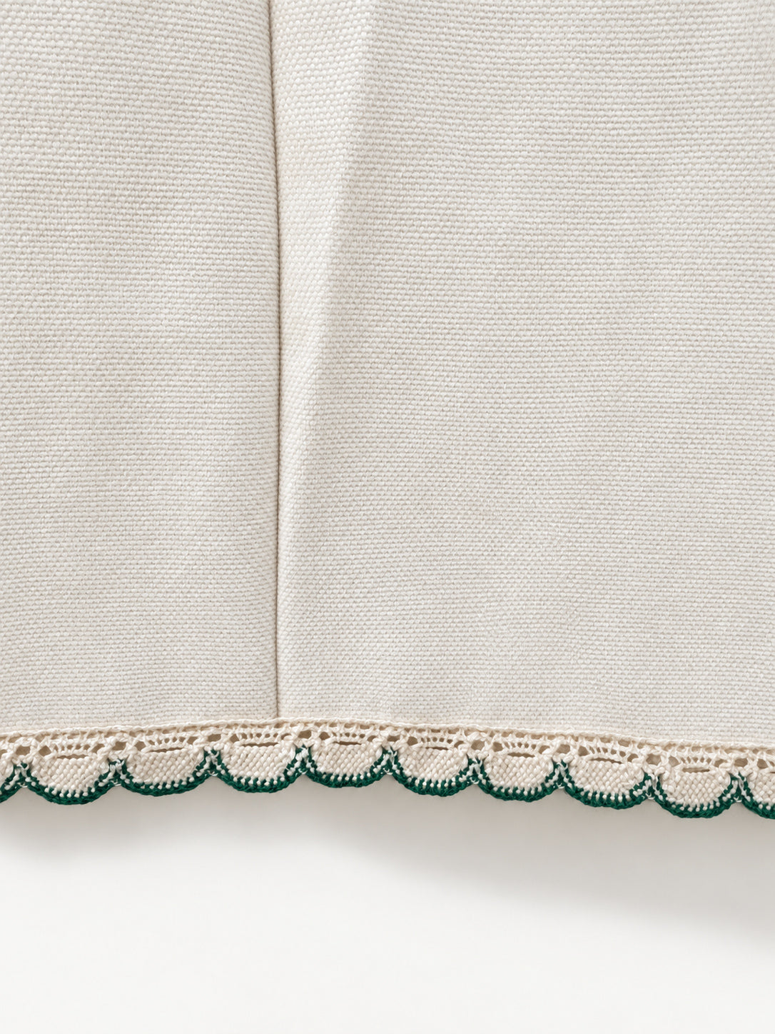 Cream skirt with green crocheted motifs and a delicate lace-trimmed hem