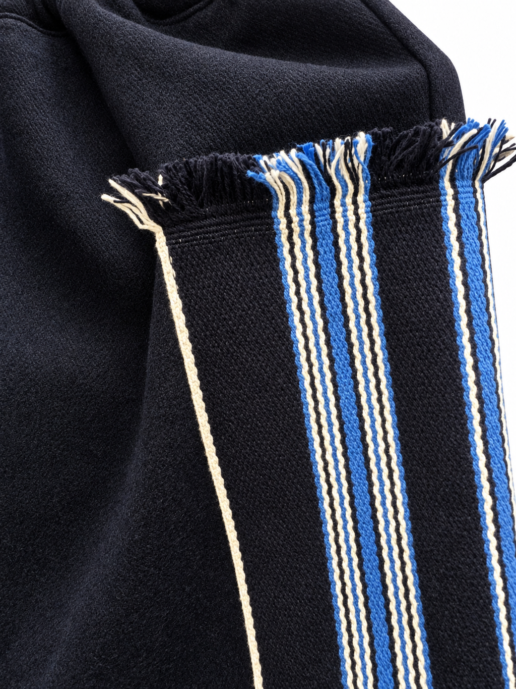 Blue-and-cream striped woven panel with fringed edge on dark wool