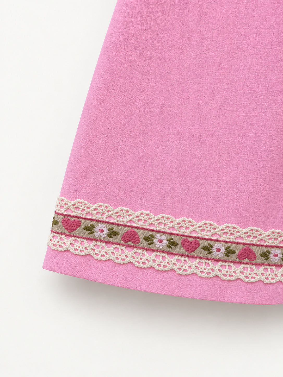 Pink skirt with an olive-green flamingo-print panel and decorative ribbon trim