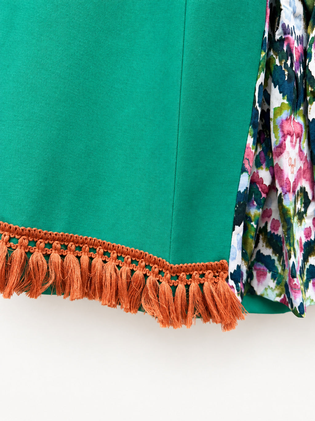 Bright green skirt with a multicoloured centre panel and orange tassel trim