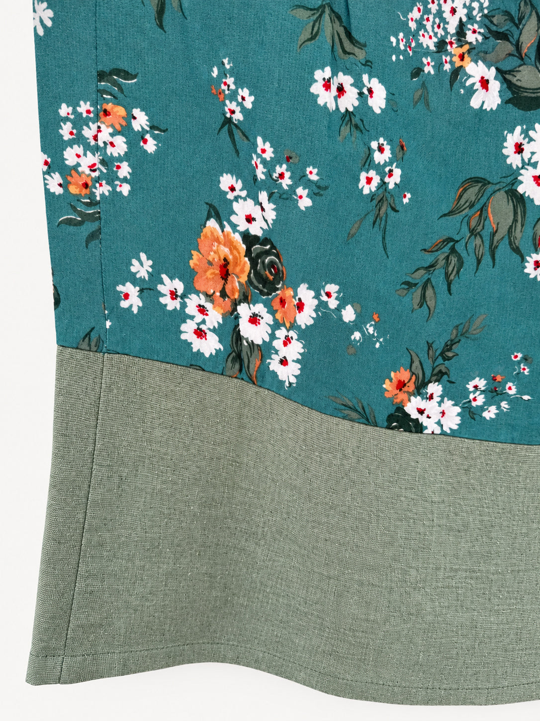 Detail of floral fabric and wide green linen hem