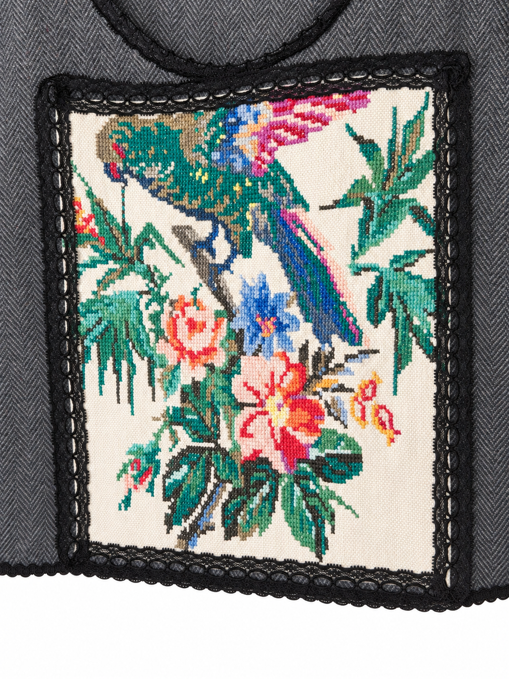 Parrot’s Garden grey herringbone vest — detail view with black lace and colourful bird embroidery