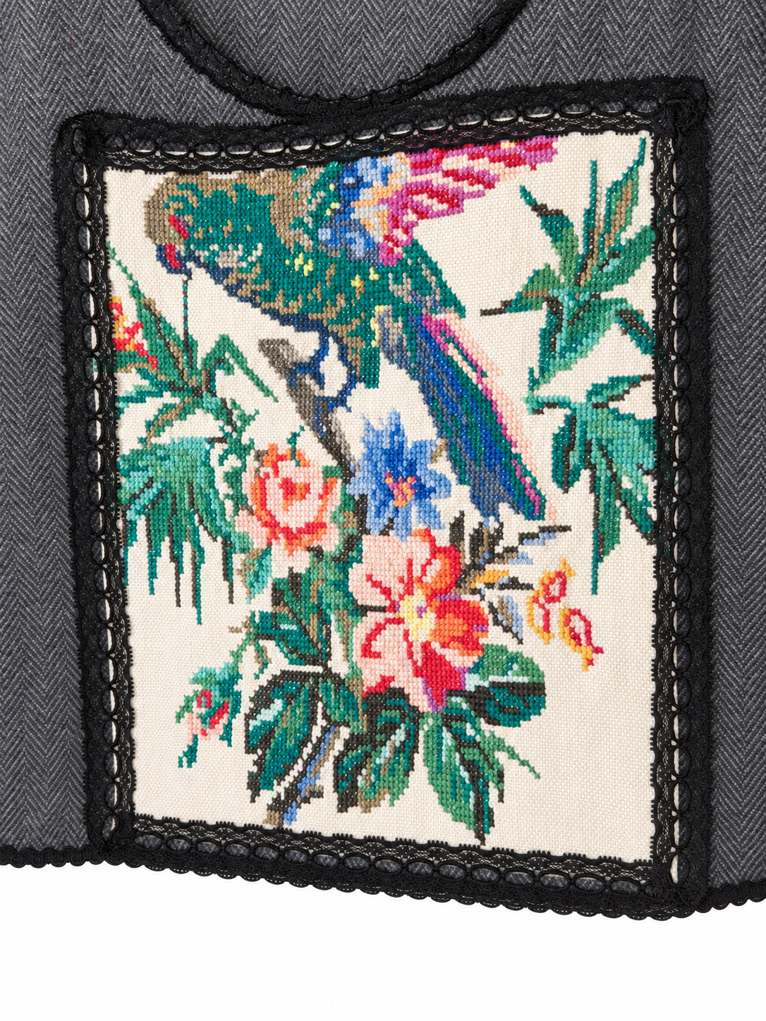 Parrot’s Garden grey herringbone vest — detail view with black lace and colourful bird embroidery