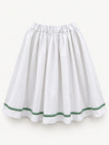 White gathered skirt with green decorative trim near the hem