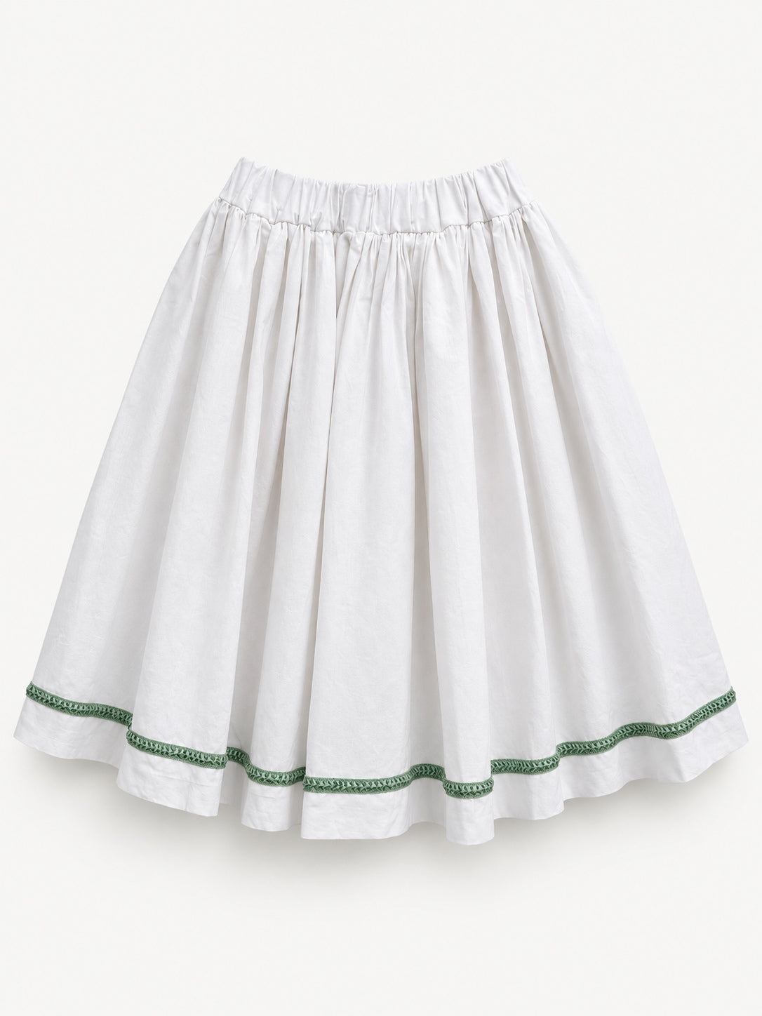 White gathered skirt with green decorative trim near the hem