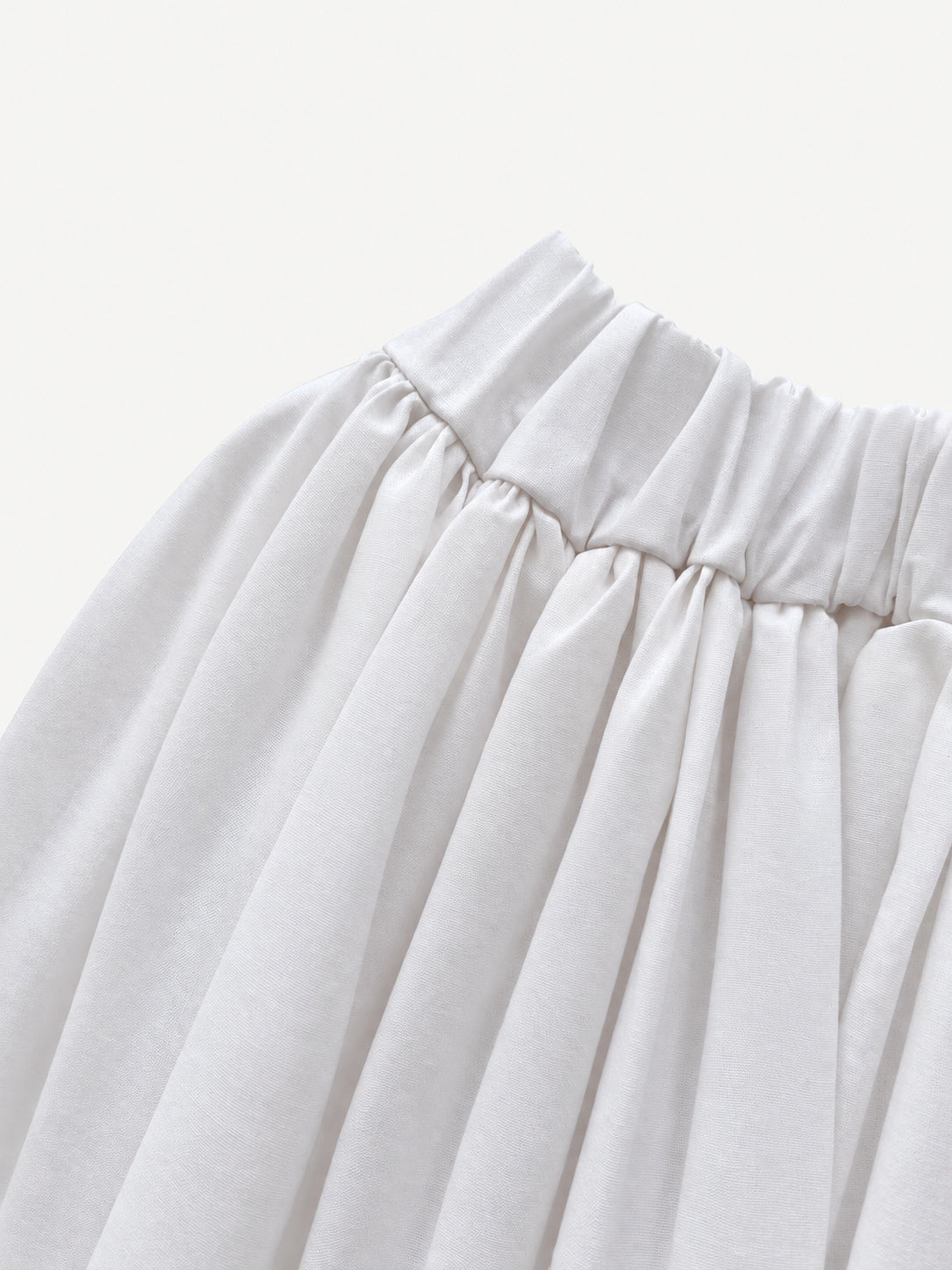 White gathered skirt with green decorative trim near the hem