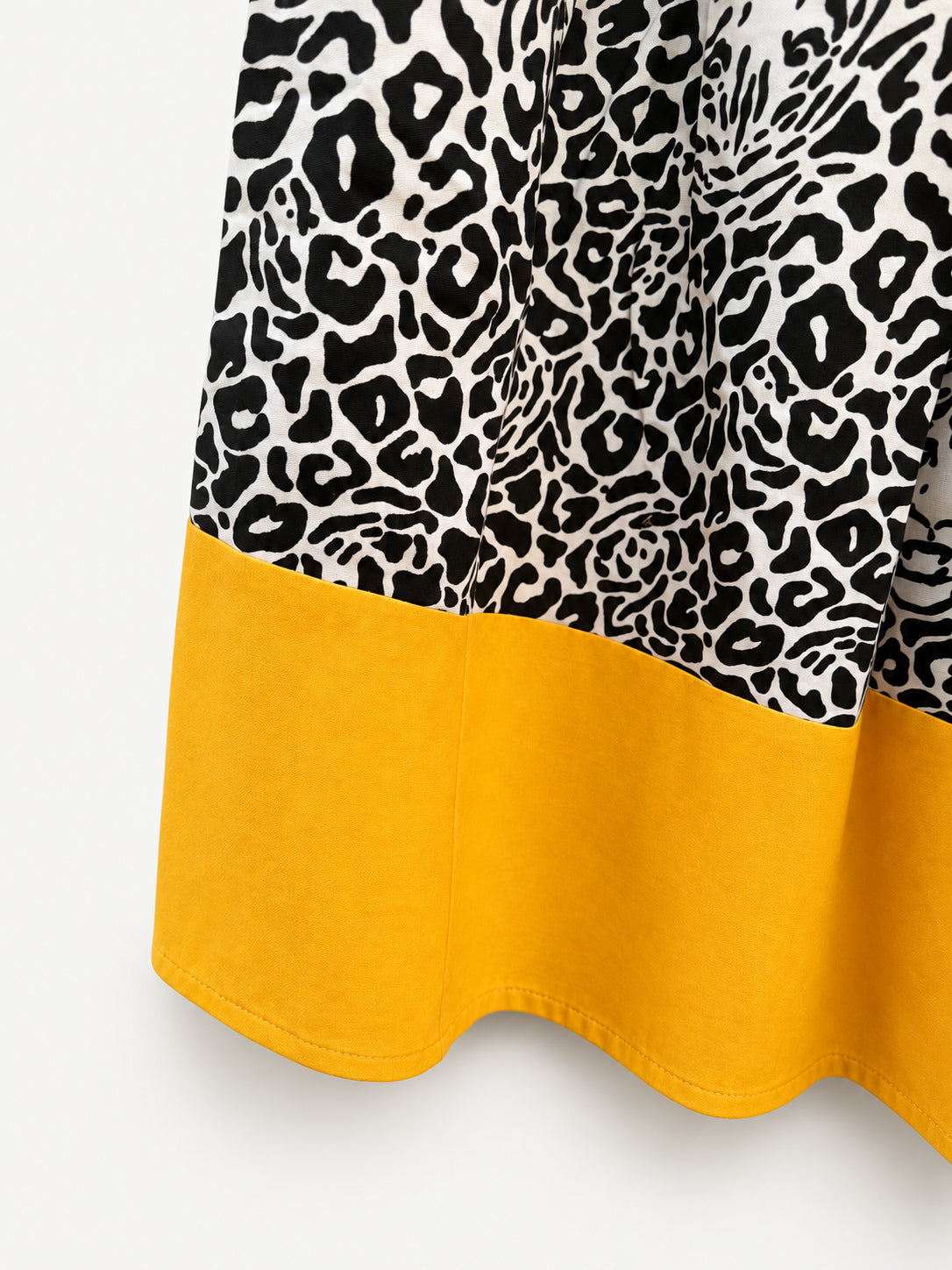 Black-and-cream leopard-print skirt with a wide yellow hem